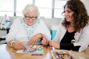 Therapist with woman who is coloring with crayons
